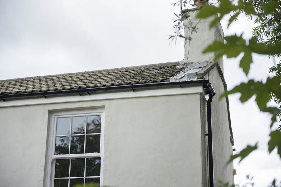 Black uPVC guttering and downpipe on corner of house